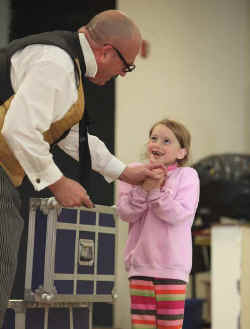 Picture at preschool fundraiser performance with smiling assistant.